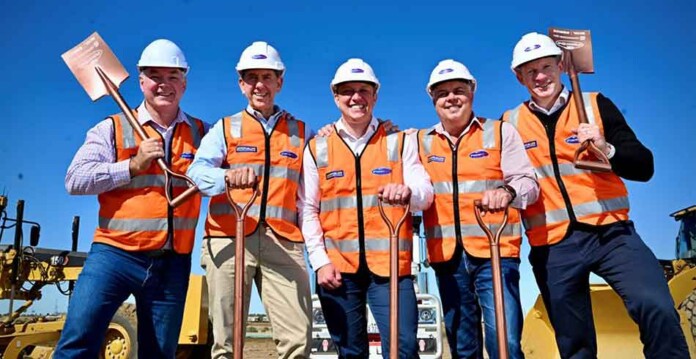 Members of Parliament and executives wearing safety fear and hard hats at sod turning event