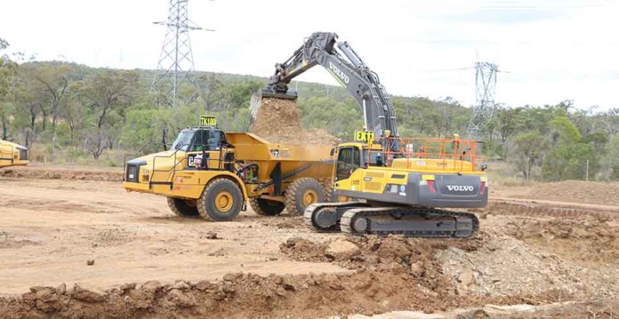 Earthwork equipment at Stanwell Battery site with transmission towers in background