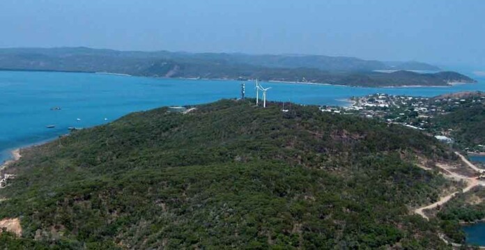 Aerial photo of Thursday Island with wind turbines and a crane, and beautiful blue ocean in background