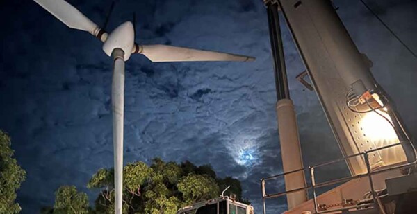 Wind turbine being lifted by crane at night on Thursday Island